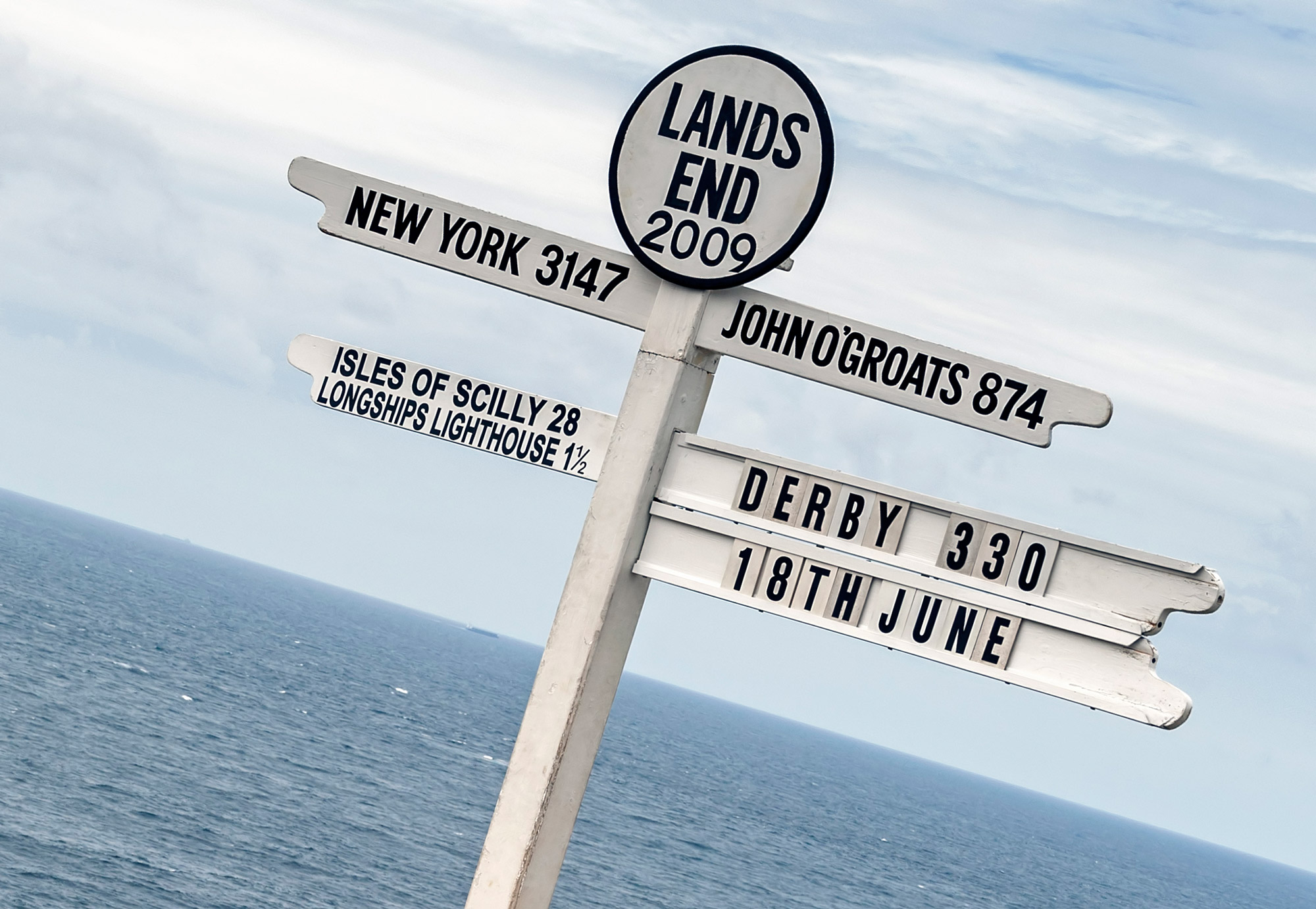 Lands End signpost showing how far to John O'Groats and New York