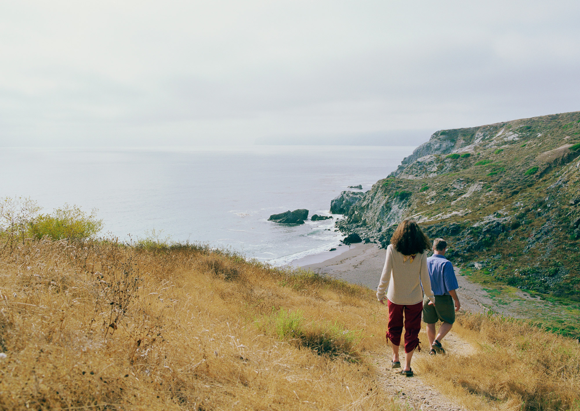 People walking the coastal path down to a secluded beach