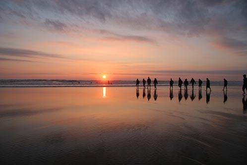 People walking on the beach at dusk