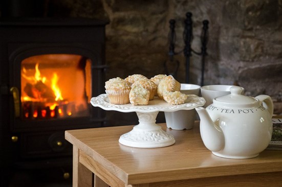 Tea and cake in front of a lit fire