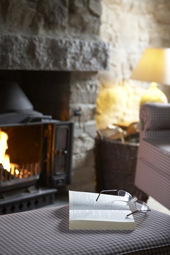 Pair of glasses and a book in front of a real fire