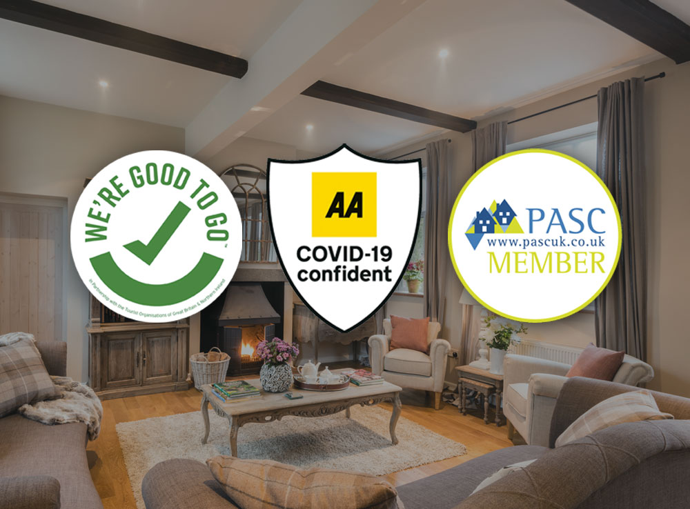Three badges from different organisations in front of a photo of a living room in a luxury holiday cottages