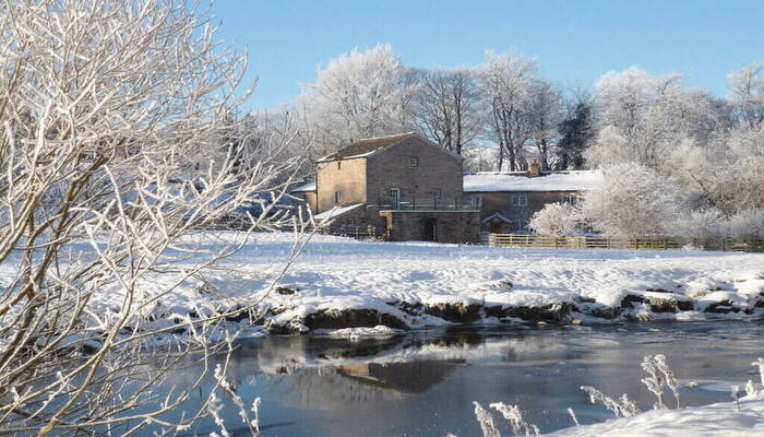 Holiday cottage in front of a snowy lake