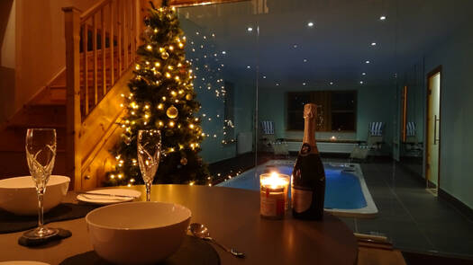 Table, chairs, champagne, Christmas tree, and swim spa in a luxury holiday cottage