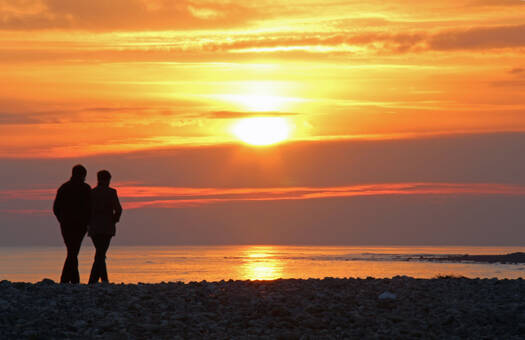 couple stood at the beach during sunset