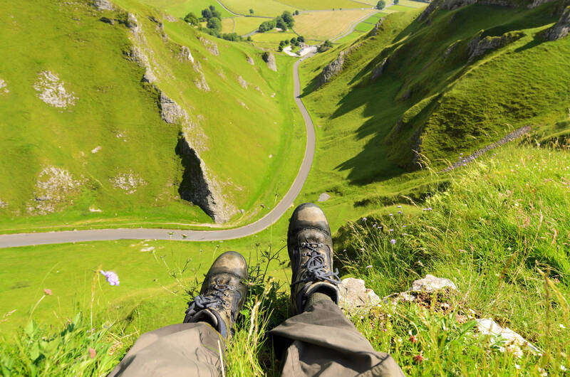 View of feet hanging over the edge of a hill