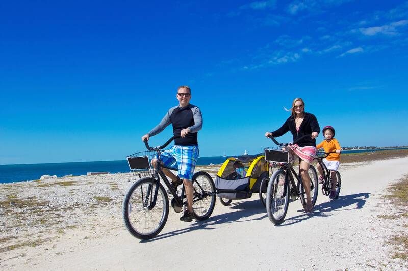 Family cycling along the coastal path with views of the sea