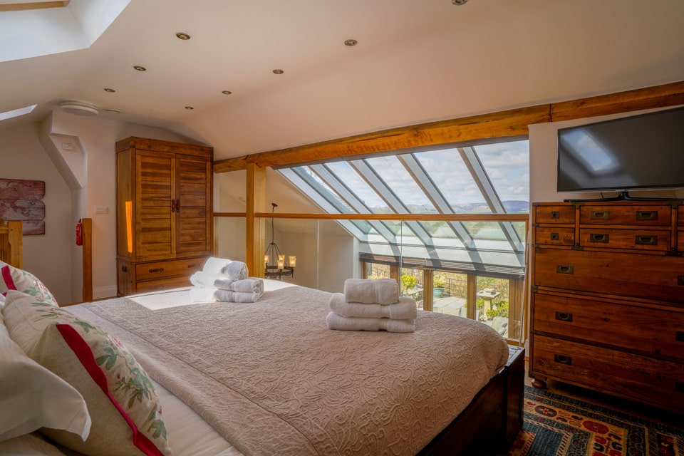 Double bed facing a window with views of the countryside