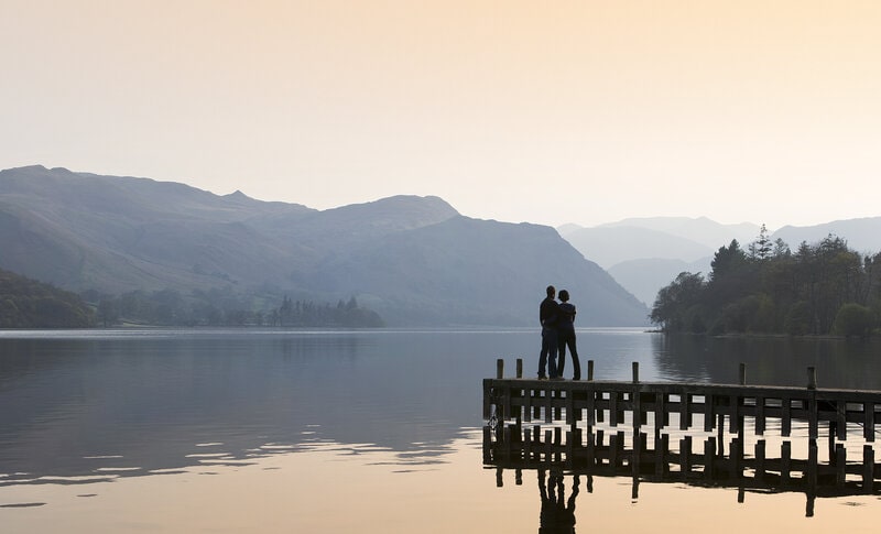 Two people stood by a lake in the Lake District