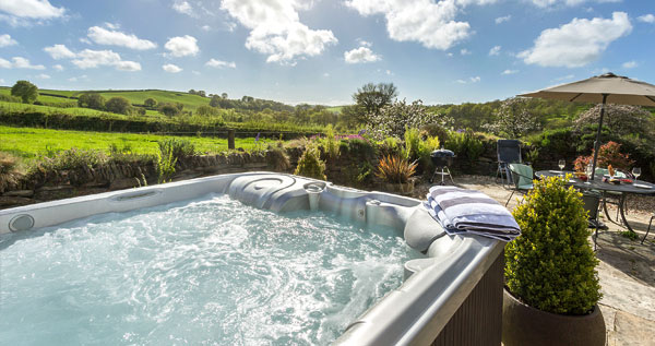 A large hot tub in a beautiful garden with plenty of jets, from one of our holiday cottages with hot tubs in the UK.