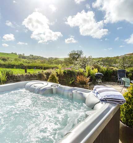 A large hot tub in a beautiful garden with plenty of jets, from one of our holiday cottages with hot tubs in the UK.